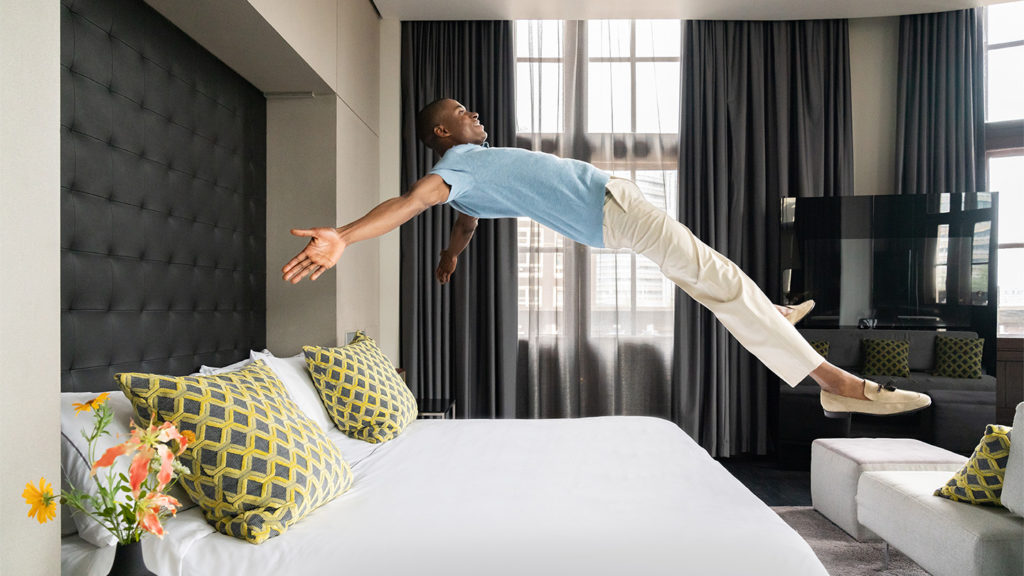 man jumping to bed at art'otel Amsterdam